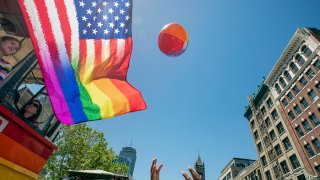 A rainbow-colored beach ball is thrown into the air at the 2019 Boston Pride Parade on June 8, 2019.