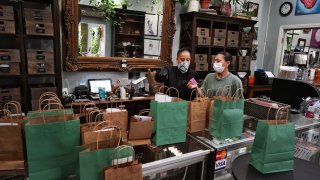 In this Thursday, April 16, 2020, photo, budtenders prepare orders for customers to pick-up at The Higher Path cannabis dispensary in the Sherman Oaks section of Los Angeles.