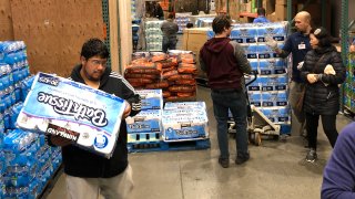Shoppers rush to pick up toilet paper that had just arrived at a Costco store, Saturday, March 7, 2020, in Tacoma, Wash.