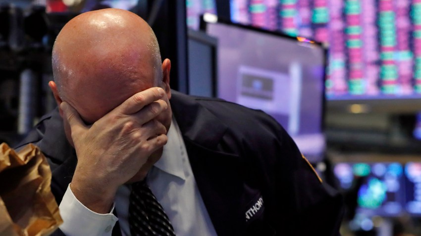 A trader has his head in his hand on the floor of the New York Stock Exchange, Thursday, March 12, 2020.