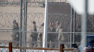 Prisoners stand outside of the federal correctional institution in Englewood, Colo.