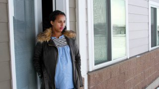 Kulule Amosa steps out of the apartment she shares with her husband who works at the Smithfield Foods pork processing plant in Sioux Falls, S.D.