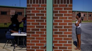 In this Thursday, May 7, 2020 photo, Azandria Torbert, stands in line for graduation information at Chattahoochee County High School after the school district called an early end to the school year, in Cusseta, Ga.