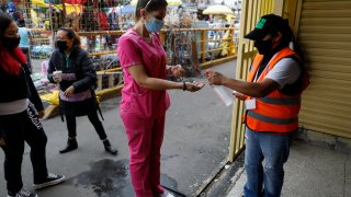 A shopper is given antibacterial gel as she enters a market