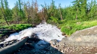water from a Norilsk Nickel enrichment plant gushing out of a pipe and into a river which also runs into the lake near Norilsk