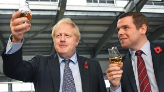 In this file photo dated Nov. 7, 2019, showing Britain's Prime Minister Boris Johnson alongside Douglas Ross, parliamentary under-secretary of state for Scotland, right in Moray, Scotland. Junior British government minister Douglas Ross has quit Tuesday May 26, 2020, over Prime Minister Boris Johnson’s failure to fire his top aide Dominic Cummings for allegedly breaching COVID-19 coronavirus lockdown rules.