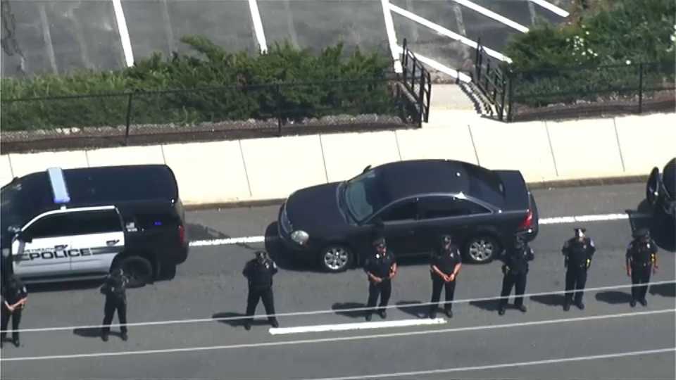 Police officers line the street as slain Weymouth Police Officer Michael Chesna is transported to the medical examiner.