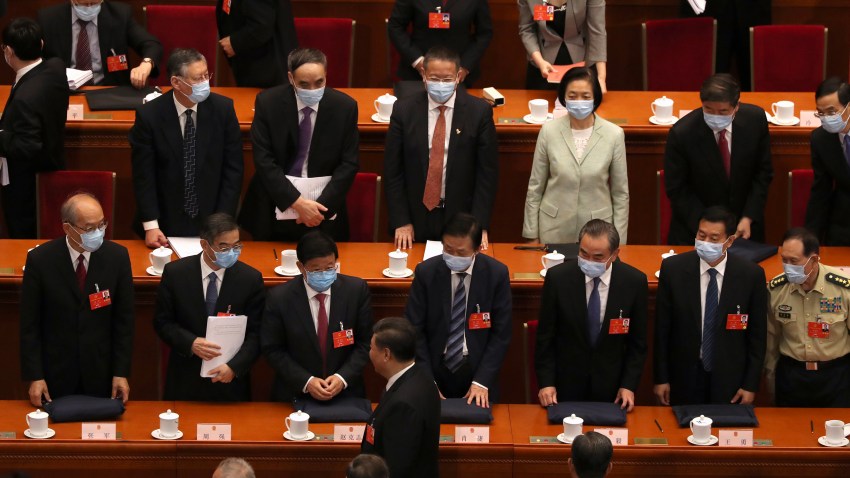 Delegates stand as Chinese President Xi Jinping, bottom center, leaves after the opening session of China's National People's Congress (NPC) at the Great Hall of the People in Beijing, Friday, May 22, 2020.