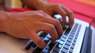 Photo of hands typing on a computer.