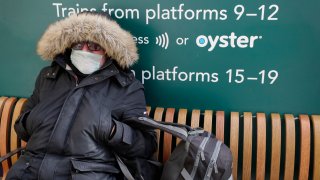 A traveller wears a mask as he waits at Victoria Station in London, Monday, March 16, 2020.