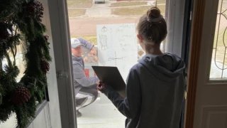 Girl receives math tutoring through her window as teacher helps from outside