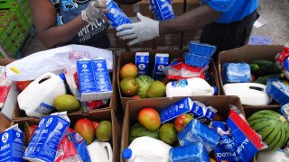 Workers fill boxes of food from the Second Harvest Food Bank of Central Florida to be distributed to needy families at a mobile food drop event at the Impact Outreach Ministry on April 6, 2020 in Orlando, Florida.