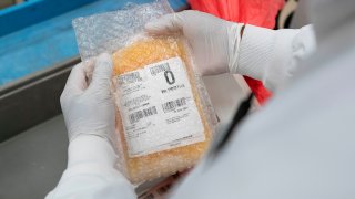 In this April 22, 2020, file photo, a lab technician freezes packs of convalescent plasma donated by recovered COVID-19 patients for shipping to local hospitals at Inova Blood Services in Dulles, Virginia.