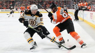 Brad Marchand of the Boston Bruins passes the puck between the legs of Jakub Voracek of the Philadelphia Flyers on March 10, 2020 at the Wells Fargo Center in Philadelphia.