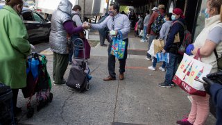 A long line forms to receive free food from a food pantry run by the Council of Peoples Organization on May 15, 2020 in the Midwood neighborhood of Brooklyn, New York.
