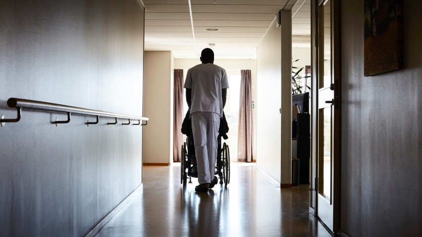 View of male nurse pushing senior man on wheelchair