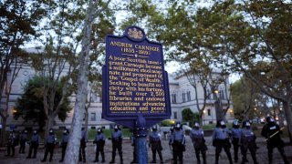 Police stand guard in front of the Carnegie Library while they try to disperse a crowd of students gathered in the Oakland section September 24, 2009 in Pittsburgh, Pennsylvania.