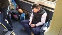Passenger sitting on floor of train