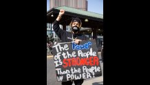 Jasper Landrum, 39, a Grafton, Mass. resident originally from Dorchester, holds up a sign that says "The Power of  the People is Stronger Than the People in Power" at the Roxbury Black Lives Matter protest on Wednesday, June 10, 2020.