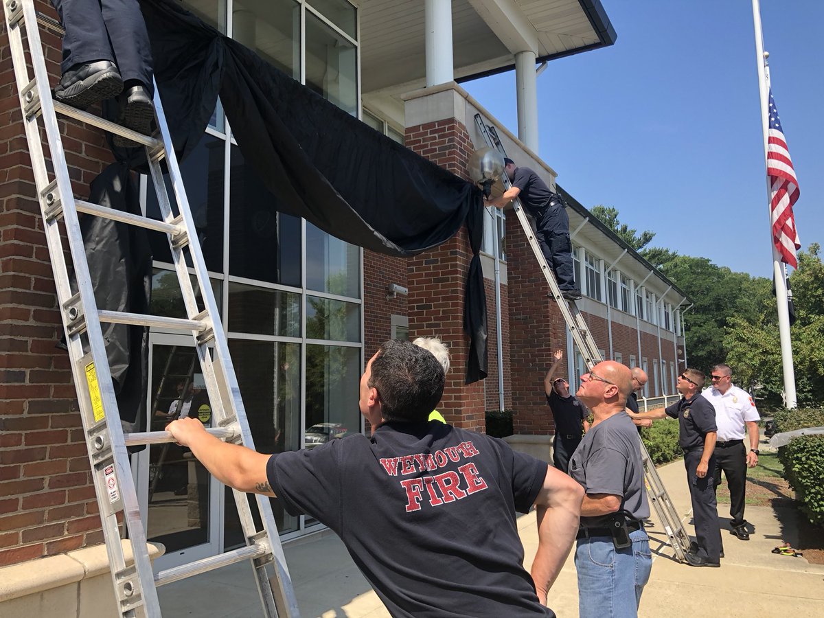 A black curtain hangs outside the Weymouth Police Department to honor Chesna.