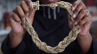 stylist holding a gold chain