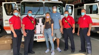 Rob Gronkowski and Camille Kostek pose with Foxboro firefighters after donating personal protective equipment