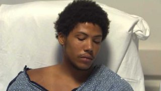 Suspect Malik Koval is arraigned from his hospital bed.
