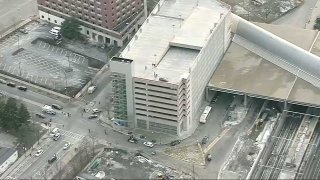 Officials investigate the deaths of two young children and a woman who were found unconscious on the sidewalk near a Northeastern University parking garage structure.