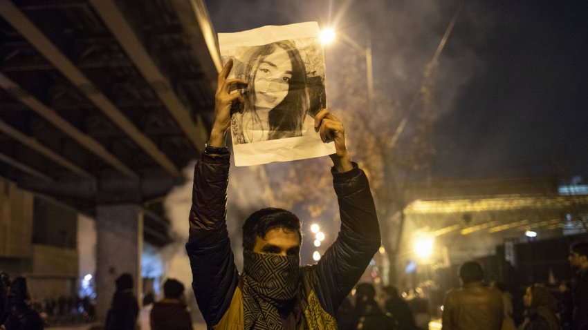 An Iranian man holds a picture of a victim of the Ukrainian Boeing 737-800 plane crash during a demonstration in front of Tehran’s Amir Kabir University on January 11, 2020. – Demonstrations broke out for a second night in a row after Iran admitted to having shot down a Ukrainian passenger jet by mistake on January 8, killing all 176 people on board.