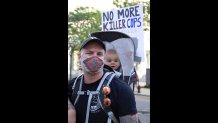 Shawn Marquis and his son, Oslo, from Waltham, stand in front of DA Rachael Rollins office during a protest on Tuesday, June 16, 2020.