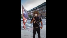 James Walker, a DJ from Brighton, holds an upside down American flag at a protest on June 16, 2020.