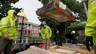 Workers inspect the top cornice stone as it is lifted from the Shaw 54th Regiment memorial opposite the Statehouse, Friday, July 17, 2020, in Boston. Amid the national reckoning on racism, the memorial to the first Black regiment of the Union Army, the Civil War unit popularized in the movie "Glory,” is facing scrutiny.