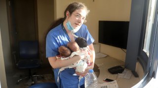 In this Aug. 4, 2020, file photo, a nurse takes care of three babies in a damaged hospital after the explosion in Beirut, Lebanon.