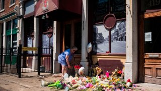 A woman lays flowers outside Ned Peppers bar in Dayton, Ohio