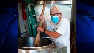 Lew Henry, of Gilmanton, N.H., stirs a pot of baked beans