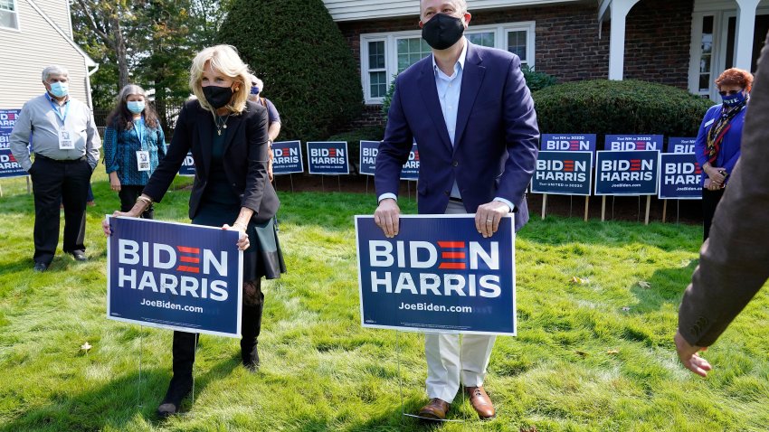 Jill Biden, front left, wife of Democratic presidential candidate former vice president Joe Biden, and Doug Emhoff, center, husband of Democratic vice presidential candidate Sen. Kamala Harris, D-Calif., place campaign placards into the ground during a campaign stop, Wednesday, Sept. 16, 2020, in Manchester, New Hampshire.