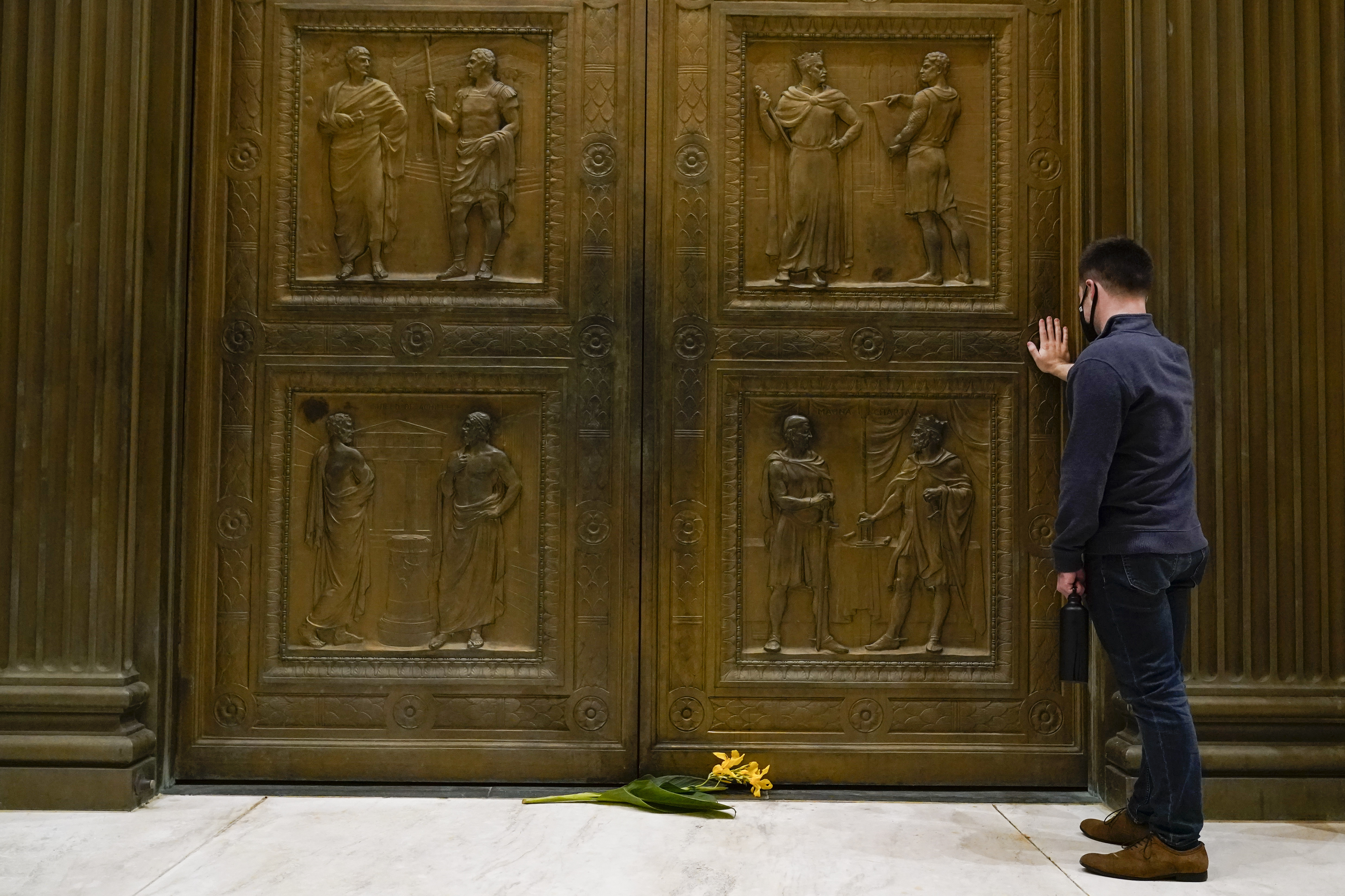 A man touches the door of the Supreme Court Friday, Sept. 18, 2020, in Washington, D.C.