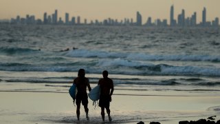 In this March 25, 2020, file photo, people are seen on the beach at Snapper Rocks, which is on the Queensland and New South Wales border at Coolangatta, in Gold Coast, Australia.