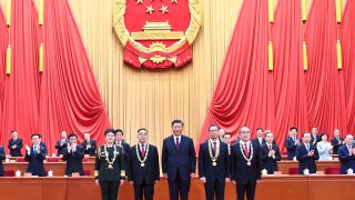 Chinese President Xi Jinping, also general secretary of the Communist Party of China Central Committee and chairman of the Central Military Commission, presents medals to the recipient of the Medal of the Republic.