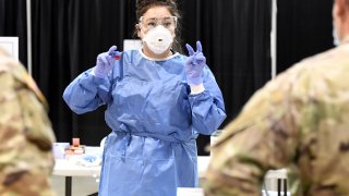 Respiratory therapist Diana Vega from University Medical Center of Southern Nevada goes over testing procedures with members of the Nevada National Guard during a preview of a new coronavirus (COVID-19) testing site inside Cashman Center on August 3, 2020 in Las Vegas, Nevada.