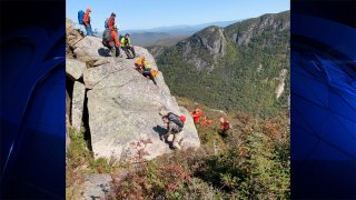 Rescue workers lift the body of a hiker who fell off a cliff in New Hampshire