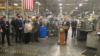 Governor Ned Lamont at a podium inside Pegasus Manufacturing