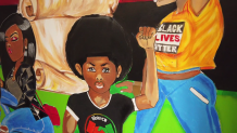 A mural in the Violence in Boston Social Impact Center showing a young man raising his fist.