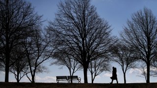 A woman walks near the shore at Boston's Castle Island