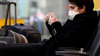 BOSTON, MA – APRIL 2: Travelers pass through the B terminal check-in concourse at Boston Logan International Airport in Boston, MA on April 2, 2020. (Photo by Craig F. Walker/The Boston Globe via Getty Images)