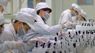 Workers are seen at a production line manufacturing solar photovoltaic components at a factory in Huzhou, Zhejiang province, China February 12, 2019.