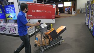 A Best Buy employee uses a cart to do shopping for an online customer at South Bay Center in Boston on Nov. 10, 2020. Retail trends are changing during the Covid-19 pandemic, and Best Buy has begun offering their holiday Black Friday sales and deals earlier in the month to thin out crowds.