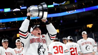 Zach Solow of the Northeastern Huskies celebrates with the winners trophy after defeating the Boston University Terriers in the 2020 Beanpot Tournament
