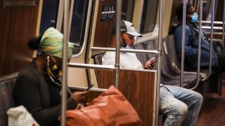 BOSTON – JULY 17: A man wears a mask on his chin while riding the MBTA Orange Line in Boston on July 17, 2020. With T ridership increasing slightly as people begin to emerge, passengers have been directing gripes at the transit agency over both strap-hangers and employees who have reportedly disregarded the state’s guidelines on face coverings in public. (Photo by Erin Clark/The Boston Globe via Getty Images)