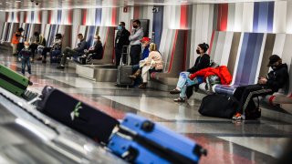 People wait for their baggage at Boston Logan International Airport in Boston